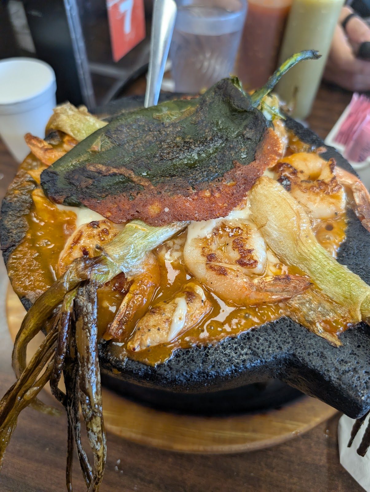 Molcajete stone bowl piled with grilled meats and nopales